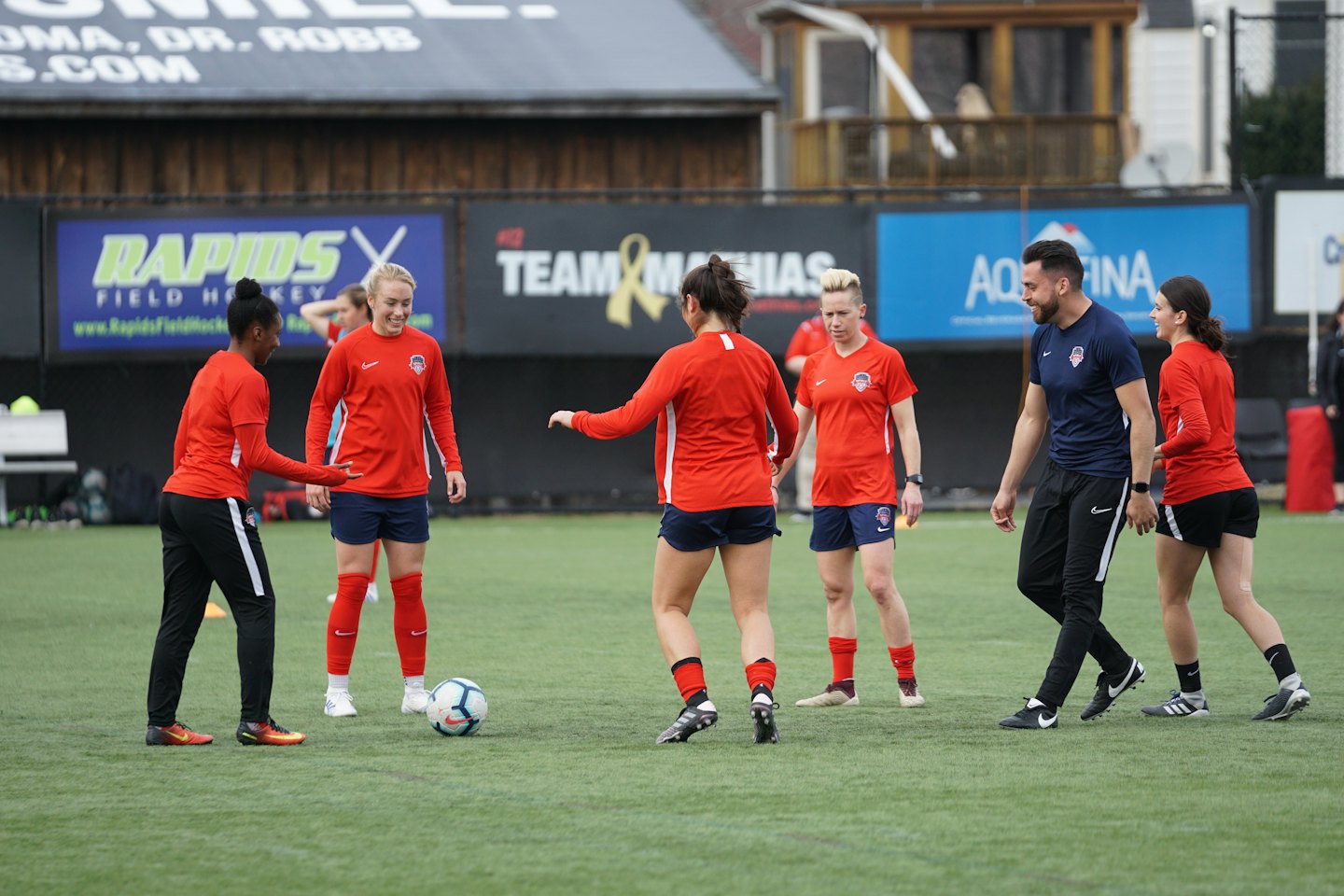 Fotbollsspelare tränar på en utomhusgräsplan.